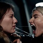 After poisoning Alex, the stranger reveals their true self as a human possessed by an alien species, stealing Alex’s seed to cultivate and breed more of the alien’s kind. After successfully accomplishing her goal to breed, the stranger prowls through the city streets at night, only to be ambushed by Melody.